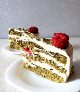 okrojony kawałek tortu z herbatą matcha i świeżymi malinami